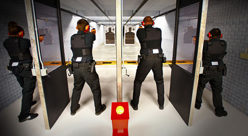 several police officers in training practicing in a shooting range