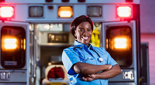 EMT standing at the back of an ambulance looking at the camera