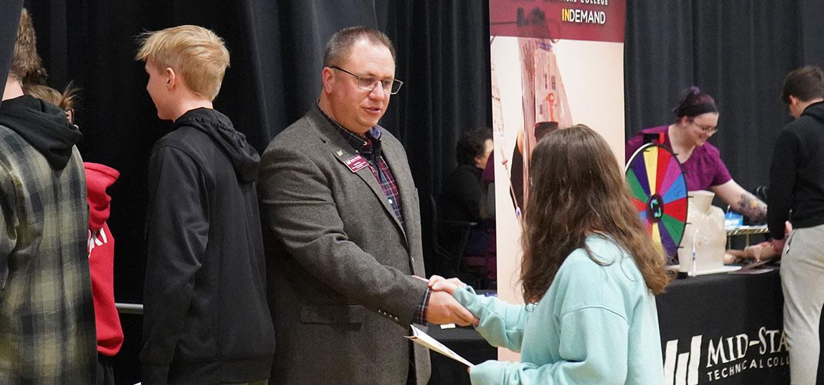 Ted Melby, Mid-State Technical College Workforce & Professional Development corporate trainer, shakes the hand of a local high school student at the March 2024 Program Showcase event. Melby will be a featured speaker at the Adams-Friendship High School Workforce Professionalism Day to be held on Thursday, April 25.