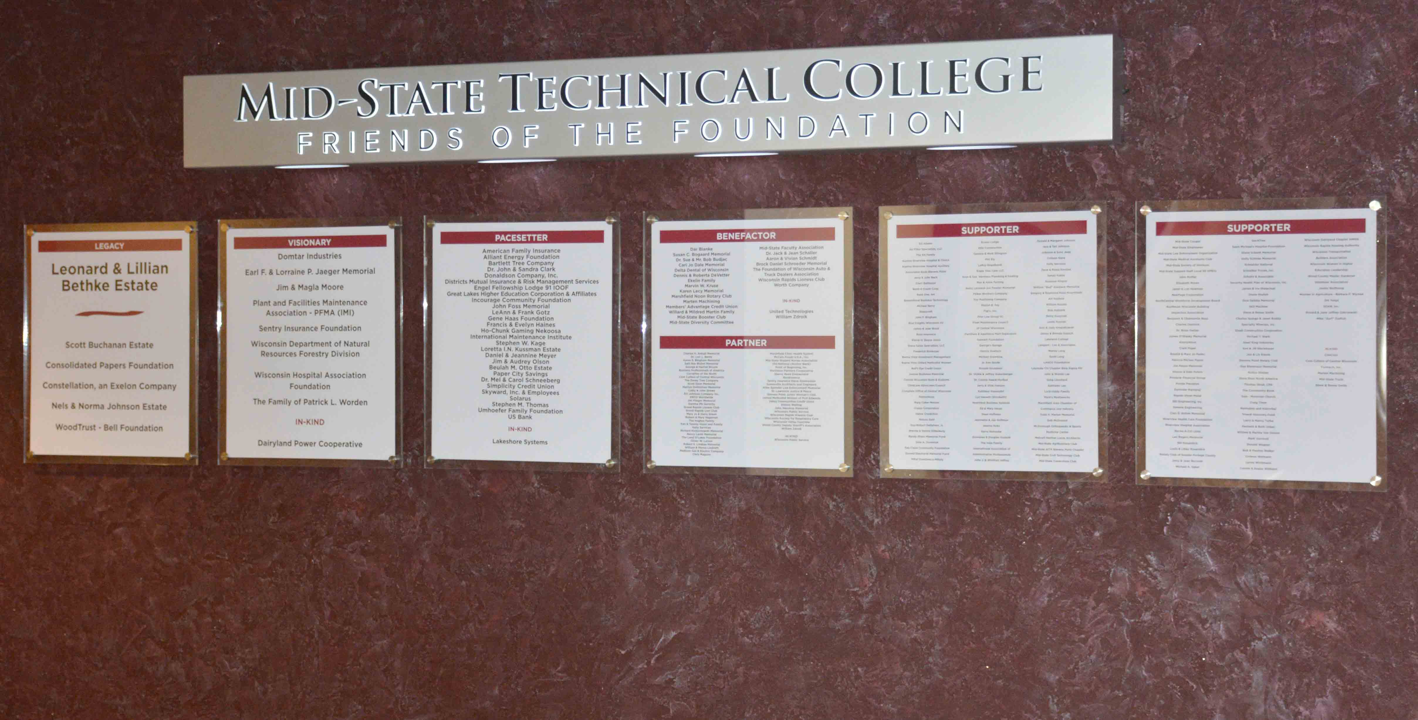 Wall with plaques listing the financial donors to the school.