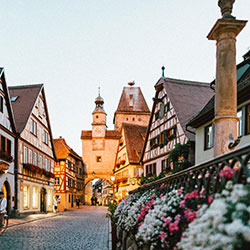 Street view of a village in Germany with flowers in the foreground, charming traditional buildings in the background - Photo by Roman Kraft on Unsplash