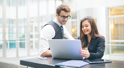 woman and man looking at a laptop together