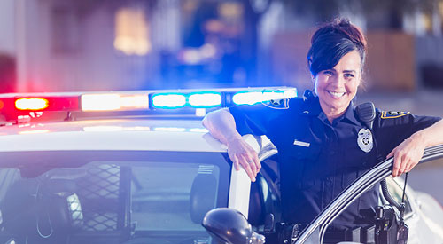 woman police officer standing next to her squad car