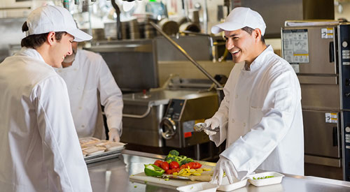 Chef plating food in an industrial kitchen