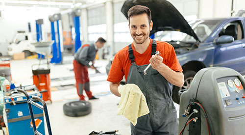 2 men in a diesel workshop one is looking at the camera