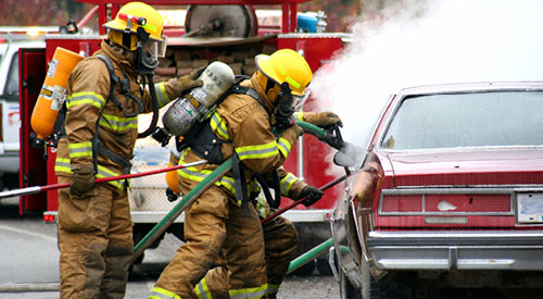 firefighters putting out a fire in a car