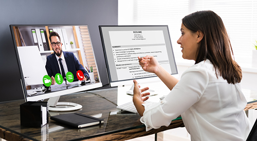 woman sitting at a desk teleconferencing with another person on one monitor. a word document is brought up on her other monitor