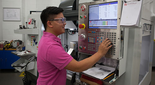 Machine tool technician working with equipment