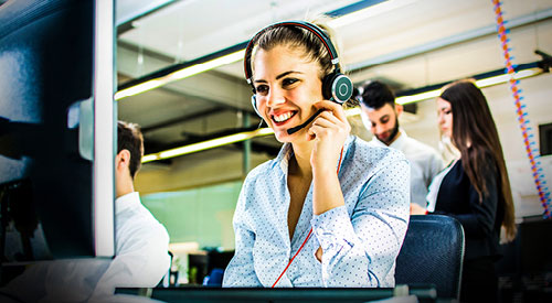 Woman sitting at a computer talking on a headset