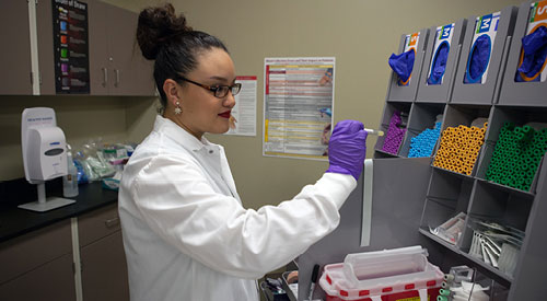 Phlebotomist organizing different empty vials into containers