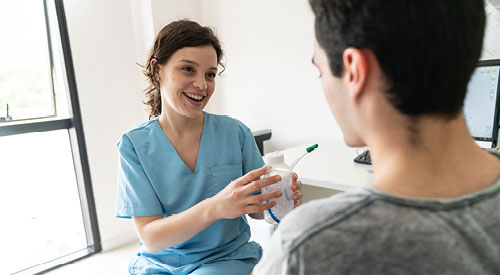 medical professional showing a patient how to use a piece of medical equipment