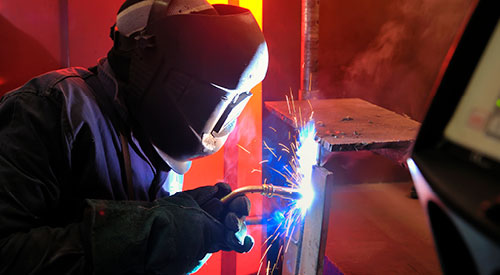 welder working on welding some metal