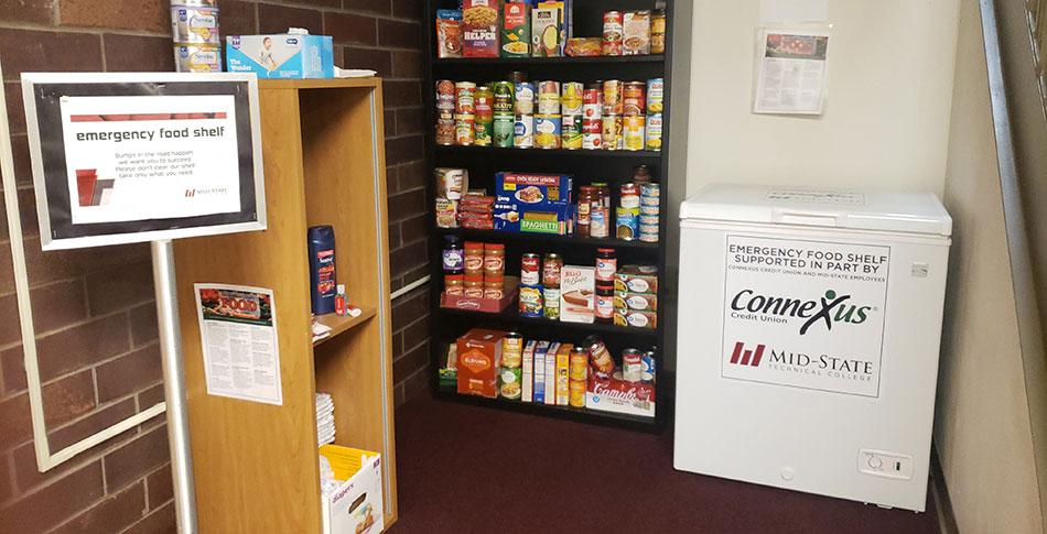 Food Pantry at the Wisconsin Rapids Campus. Shelves stocked with canned and boxed goods, and a mini freezer.