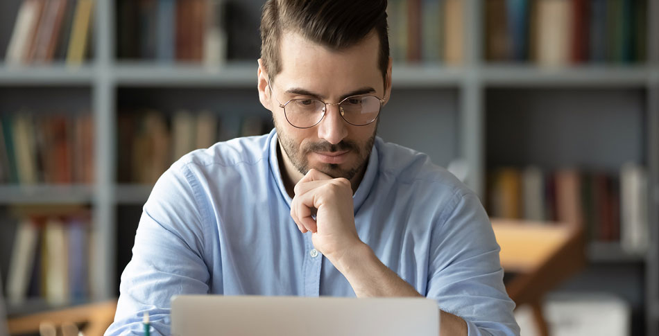 Person sitting at a laptop contemplating