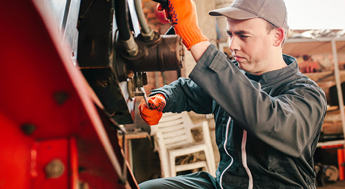 Person tightening a screw on the back of a truck