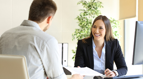 Employee meeting with an HR representative sitting at their desk