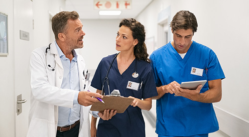 2 nurses taking feedback from a doctor