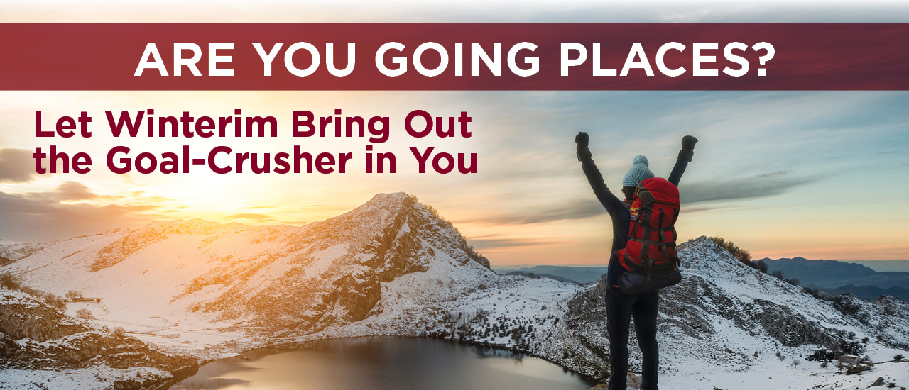 Are you going places? Let winterim bring out the goal-crusher in you. person on snowy mountains with hands in the air overlooking a lake in the middle