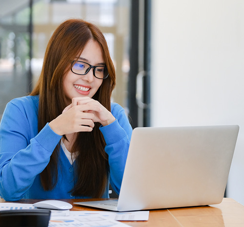 person sitting at a desk looking at an open laptop