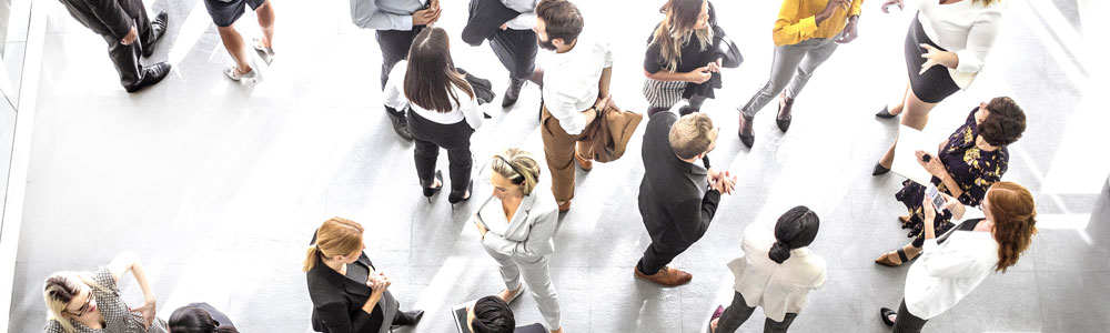 Birds eye view of people standing around together in a conference room