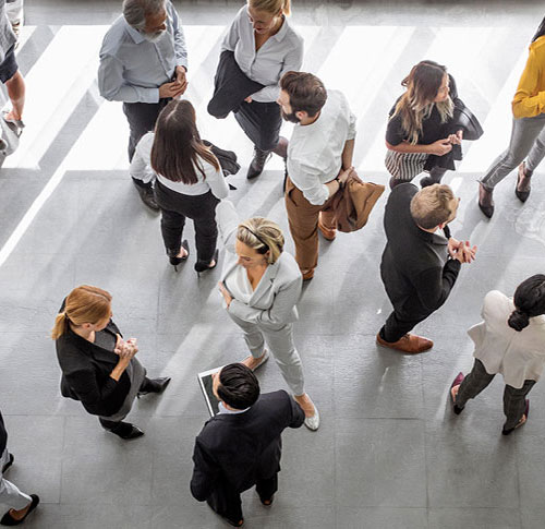 Birds eye view of people standing around together in a conference room