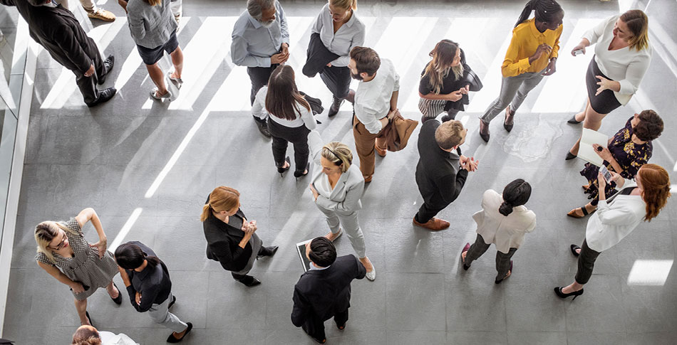 Birds eye view of people standing around together in a conference room