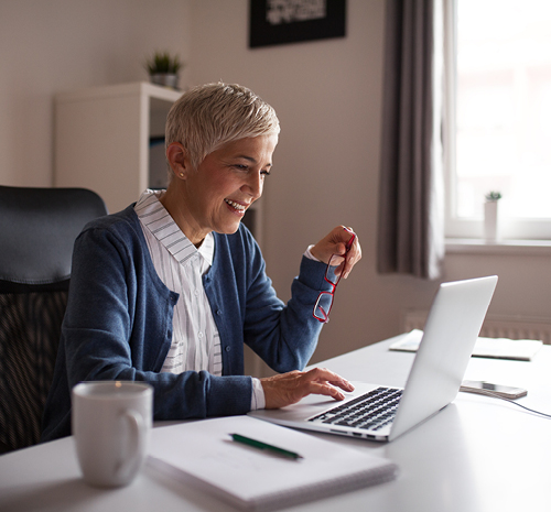 Woman working on her laptop in her home office.