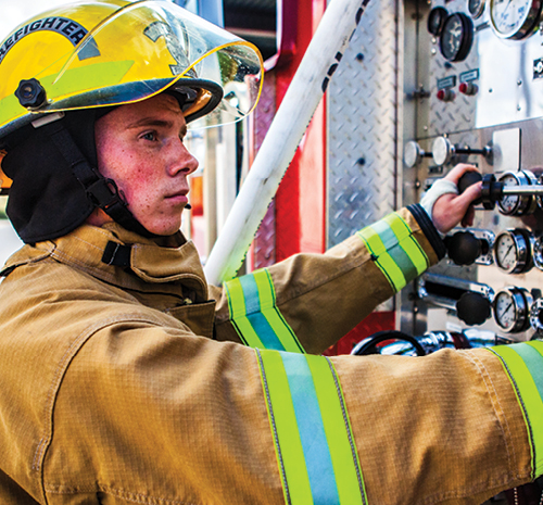 Firefighter in gear works on fire truck