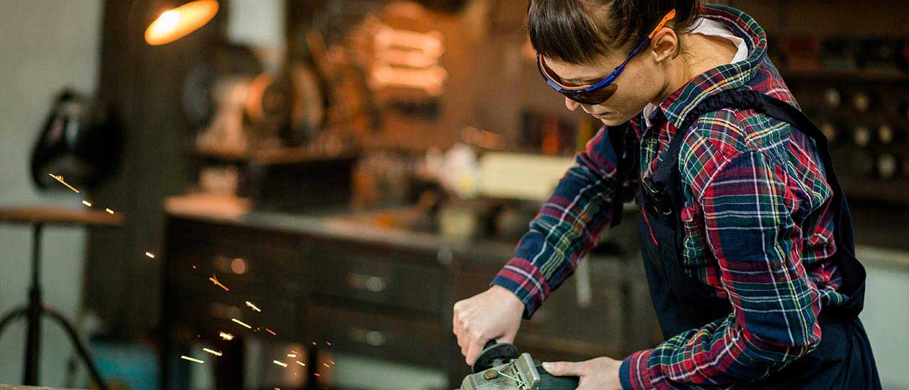 Millwright at work using a grinder shooting sparks