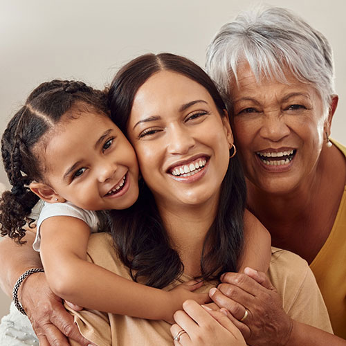 Grandma, mom, and child embrace.