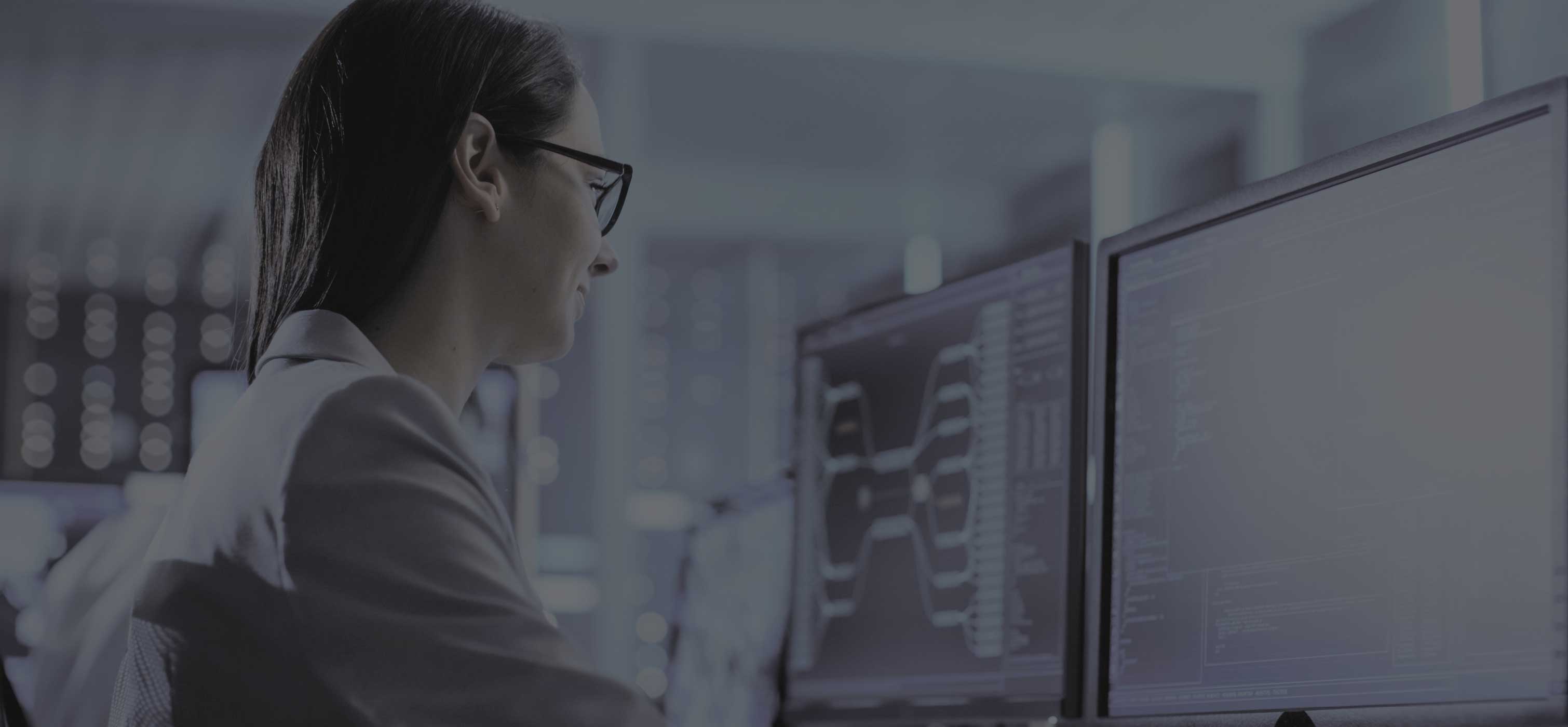 Person sitting in front of 2 monitors looking at code