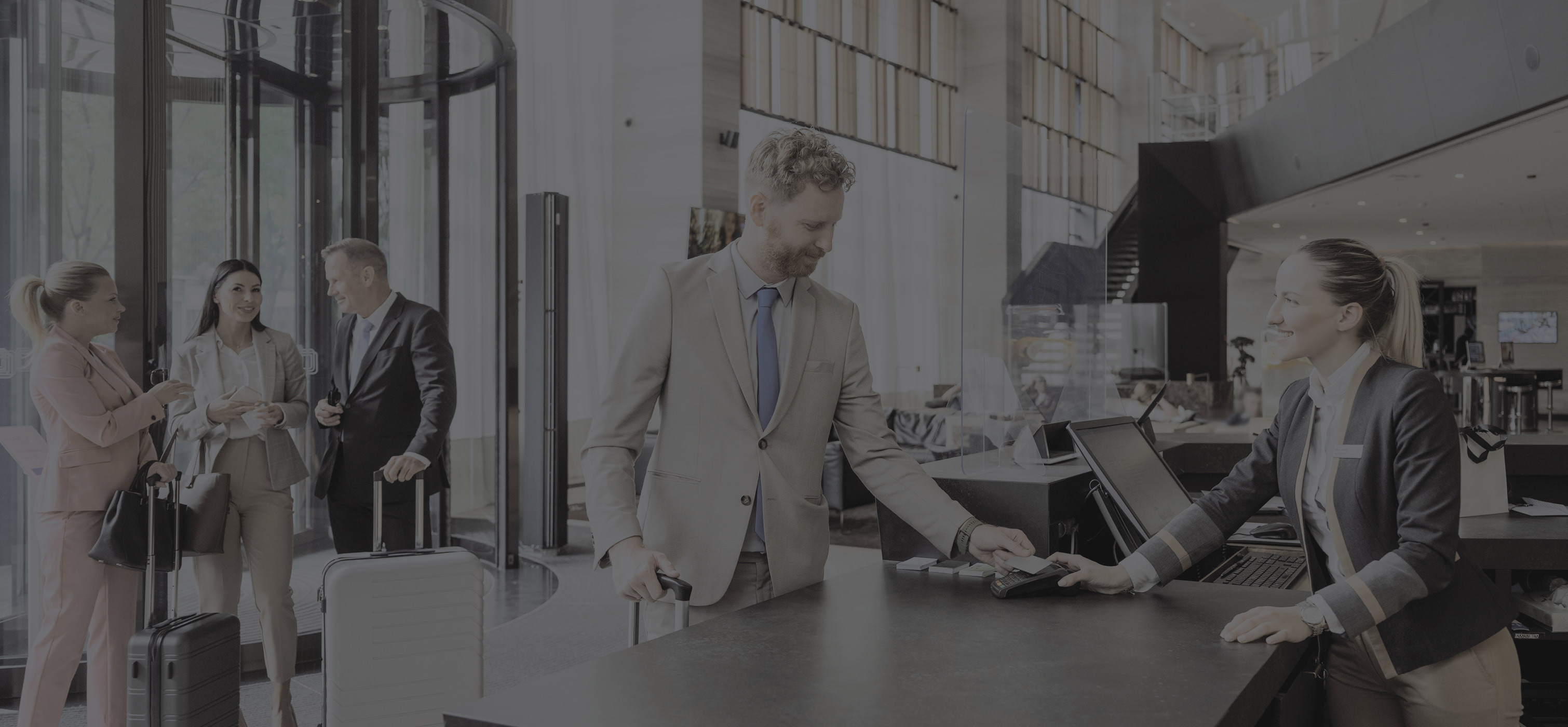 Front desk at a hotel. Person checking in to a hotel person behind the counter is helping them