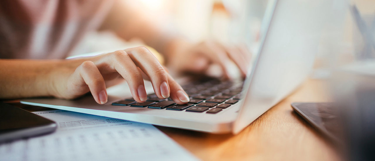 Hands typing on a laptop.