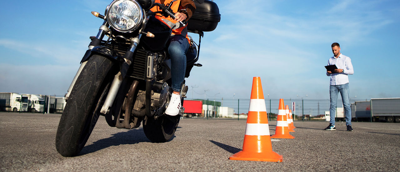 Motorcyclist practicing driving skills with cones.