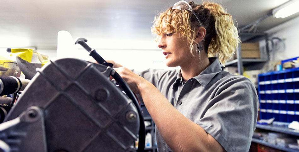 Woman participates in her non-traditional occupation in an automotive setting.
