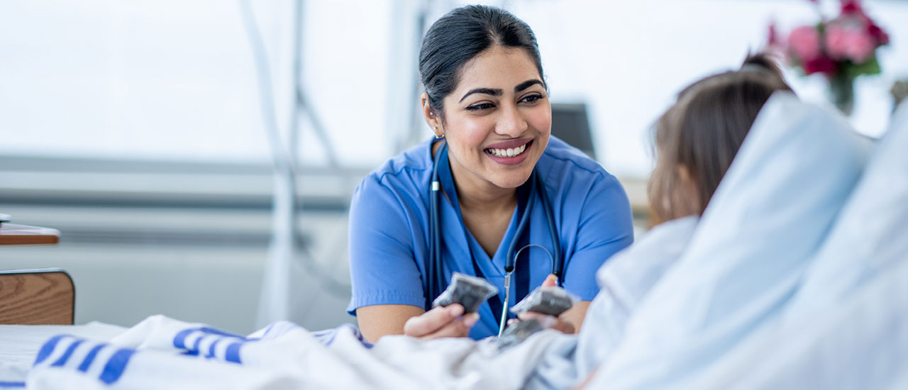 Bedside nurse attends to patient.