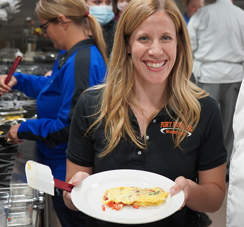 Counselor from Port Edwards holding a plate with an omelet on it
