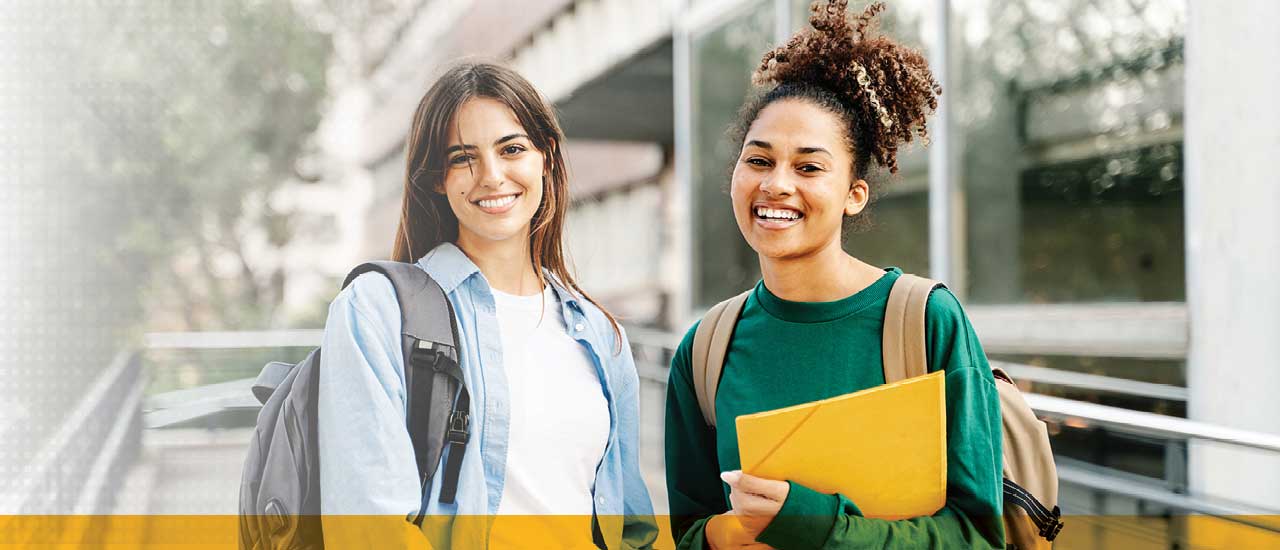 two people with backpacks, one holding a yellow folder, looking at the camera