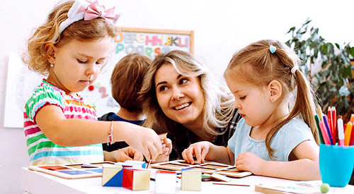 Teacher working with early childhood students in a classroom