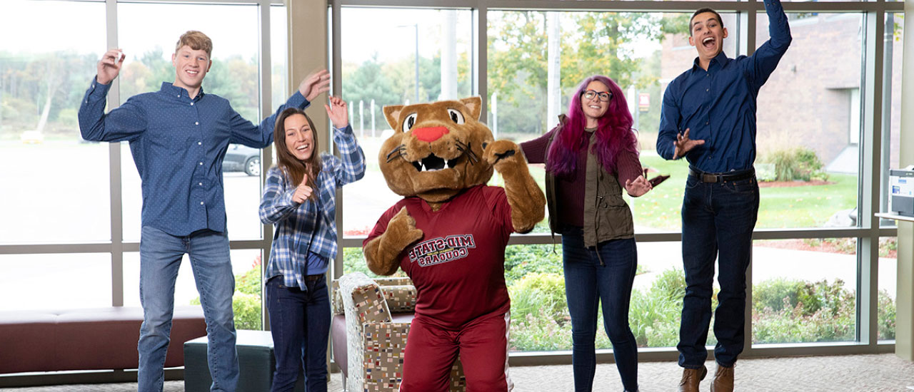 Mid-State students jumping with the mascot, Grit.