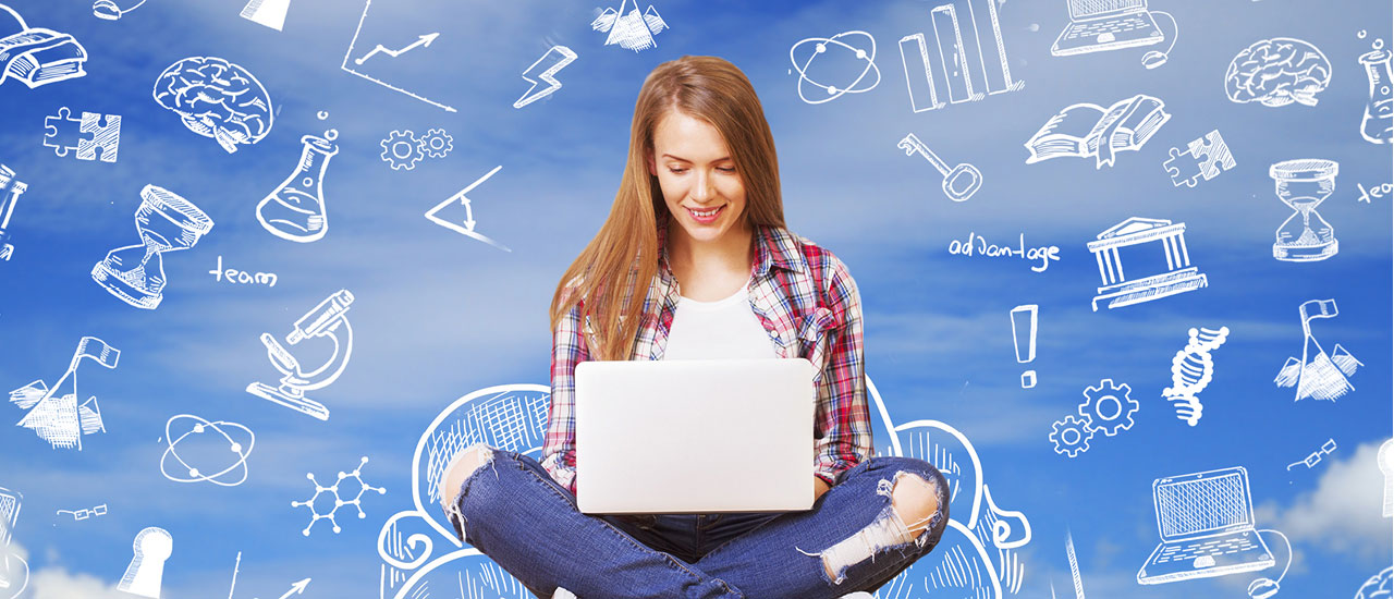 Woman sitting in front of a chalkboard with a laptop