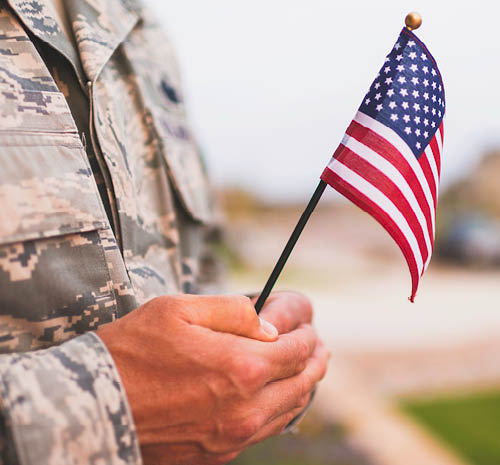 Person in uniform holding a small American flag