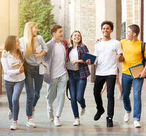 Group of teenagers walking in a line holding school supplies.