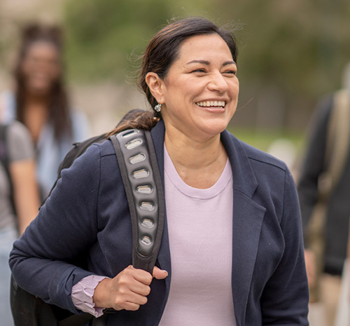 Person walking with a backpack over their right shoulder