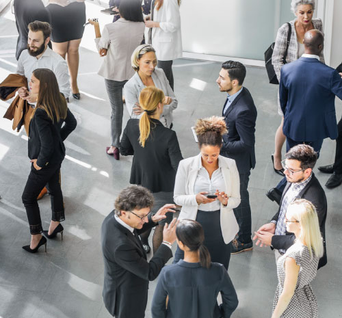 Balcony shot of people standing in a conference room having conversations