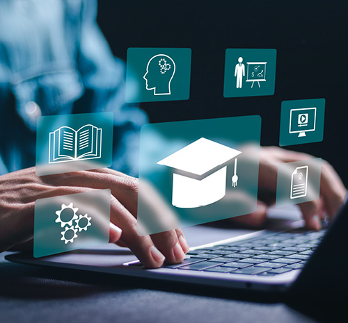 Person typing on a laptop with education icons floating above.