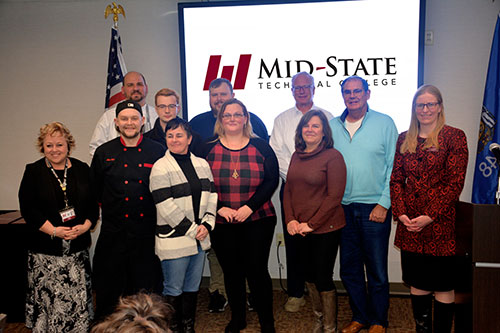 Mid-State Technical College’s first Culinary Foundations certificate completers with College officials and community partners at the recognition ceremony held in the Gourmet Café on the Wisconsin Rapids Campus, Feb. 15. Pictured from left: Mid-State President Dr. Shelly Mondeik; completer Max Bell; Culinary Arts instructor Ryan Petrouske; completers Jared Craig and Tawnya Penyak; Visit Rome WI Board Treasurer Will Beckstrom; completer Angela Kolb; Town of Rome Board Supervisor Bob Baurhyte; Visit Rome WI Executive Director Lisa Kubis; Visit Rome WI Board Vice President Robb Sigler; and Mid-State Dean of Business & Technology Dr. Missy Skursewki-Servant. Not pictured: completer Michael Tennessen.