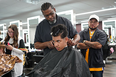 A young “Cuts 4 Kids” participant receives a free haircut from a Mid-State Technical College Barber Technologist student in The Salon at Mid-State, June 11.