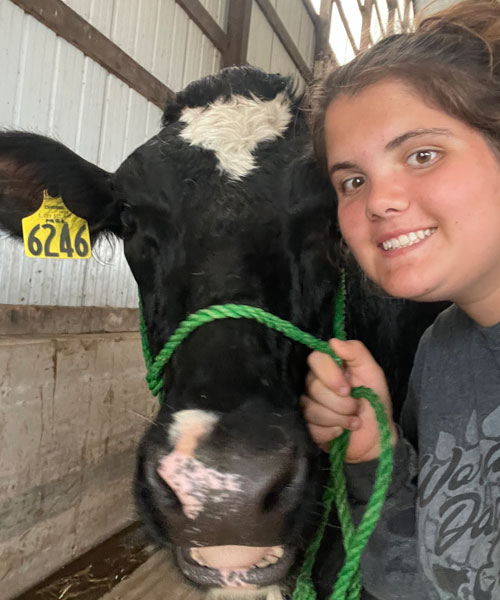 Macy Kloos with a Holstein cow