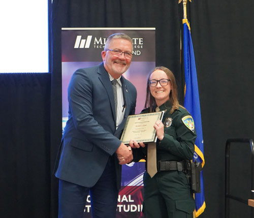 Mariah Guyer (right), Law Enforcement Academy graduate, accepts her certificate of completion from Kurt Heuer (left), Law Enforcement Academy director.